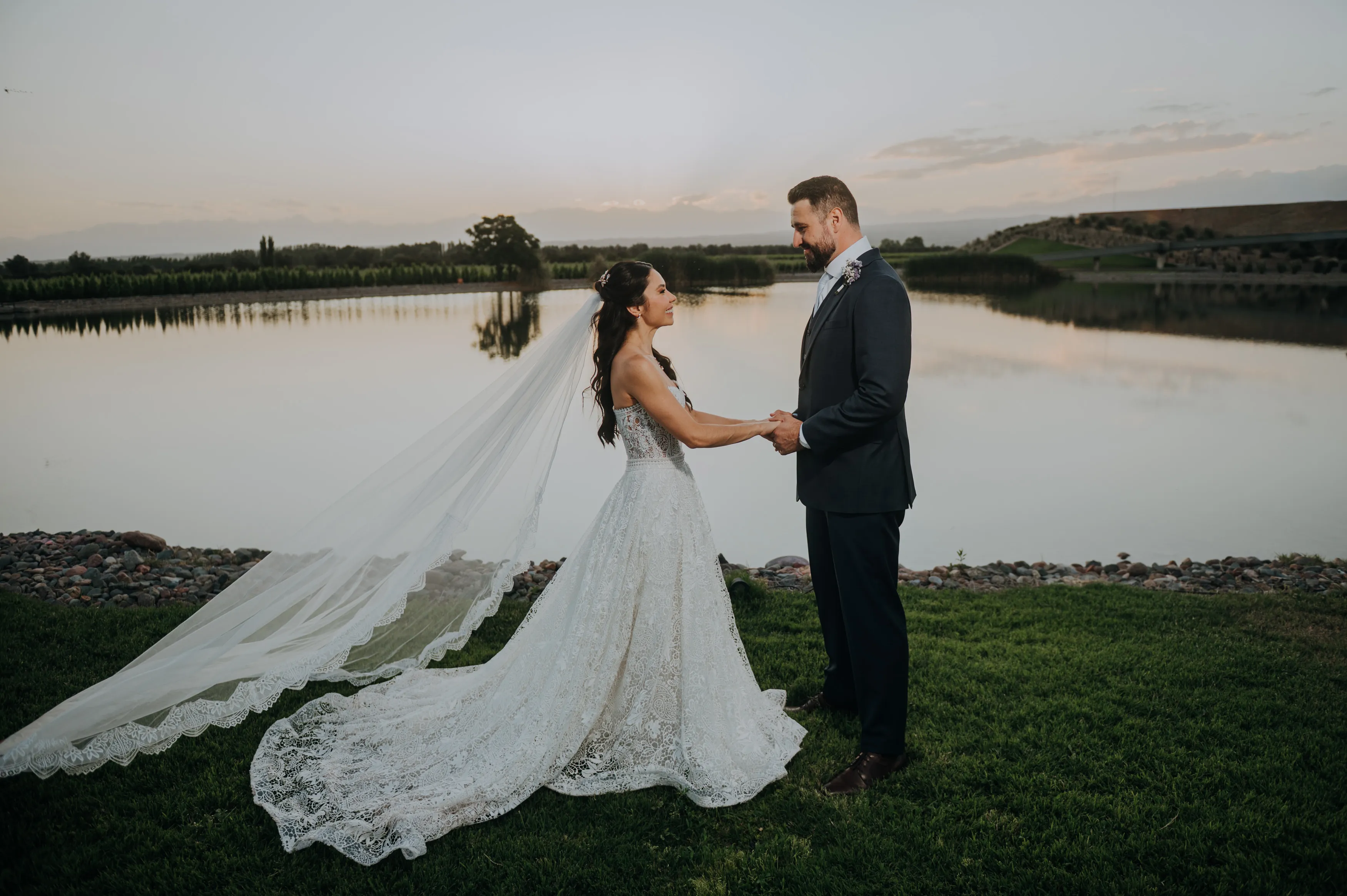 Casal de noivos ao entardecer à beira do lago